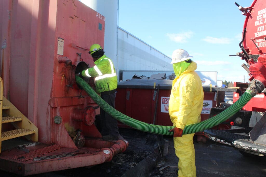 Elk team putting vacuum hose from our super sucker into the frac tank.